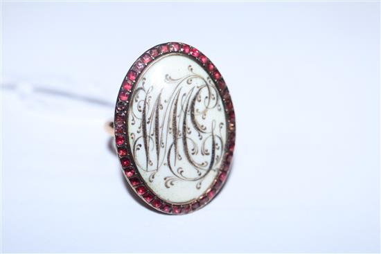 A Regency yellow metal, monogrammed ivory? panel oval mourning ring with garnet set border, size L.